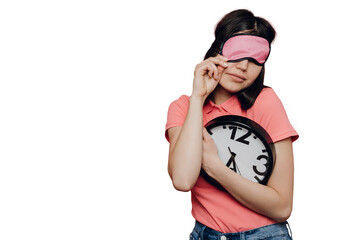 Sleepy girl in casual clothes with sleeping mask on face holds wall clock can’t awake standing...