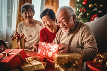 Elderly Asian trio joyfully share a moment, examining a Christmas gift. Brightly wrapped presents and a decorated tree set a festive backdrop