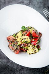 salad of tomatoes, zucchini, grated garlic with a lot of sesame seeds, top view