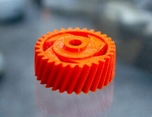 Many orange detail printed on 3D printer close-up. Part 3D printed from molten plastic. FDM...