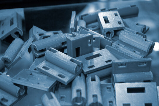 Many blue details printed on 3D printer close-up. Parts 3D printed from molten plastic. FDM technologies. Additive progressive modern new technology. 3D printing technology. Innovation prototyping