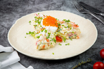 salad with mozzarella, caviar and green onions on a white plate, side view