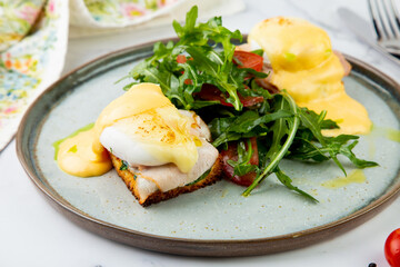 breakfast of arugula and tomato, toast with cheese and poached egg, top view