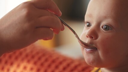 a small child eats. happy family childhood dream concept. little newborn eating yogurt from a spoon...