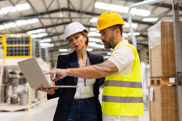 Female manager talking with foreman, checking production plan on notebook. Woman quality controller checking quality of products, talking with technician.