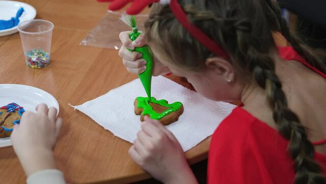 Master class on making Christmas ginger strands. Children paint gingerbread cookies with icing.