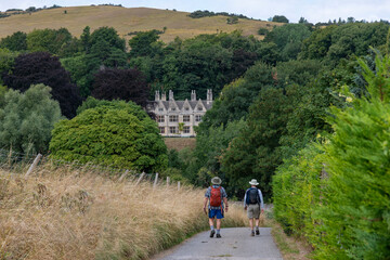 High angle view over downward sloping public footpath Cotswolds Way near Winchcombe, UK with two...