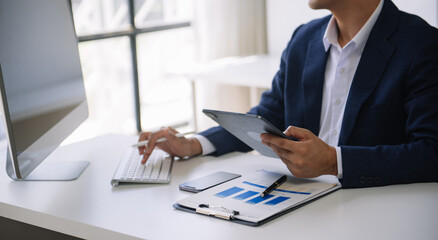 Man accountant use Laptop and calculator to calculate the company's financial with icon banking on data network of finance and banking