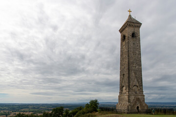 Fototapeta na wymiar Low angle view of Tyndale Monument at North Nibley, Gloucestershire, UK, built in honor of William Tyndale overlooking the Cotswold Edge with footpath Cotswold Way passing the monument