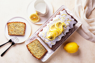 Top view of homemade breakfast. Sliced pound cake with lemon zest, sugar and lemon glaze, poppy...
