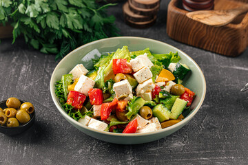 Portion of fresh greek salad on grey background
