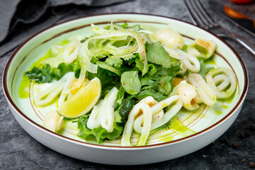 salad with arugula, parsley, lime and squid rings, side view