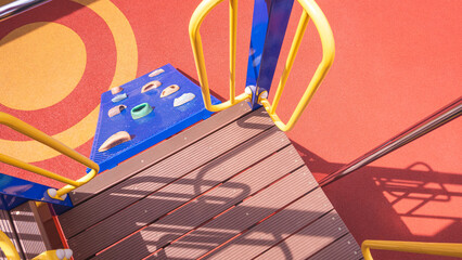 Sunlight and shadow on fiber walkway of climbing playground equipment with jungle gym on safety rubber floor in outdoors playground area at kindergarten, view from above