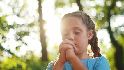 child pray. young gratitude a god religion concept. little girl in nature outdoors praying dreams of happiness to god. praise worship freedom concept. kid praying in the forest lifestyle