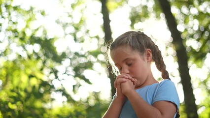 child pray. young gratitude a god religion concept. lifestyle little girl in nature outdoors praying dreams of happiness to god. praise worship freedom concept. kid praying in the forest