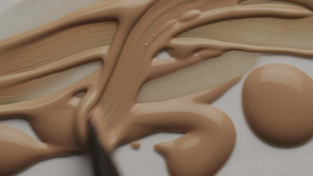 Glossy cosmetic texture, beige liquid foundation or concealer as beauty make-up product background, skincare cosmetics and luxury makeup brand design concept