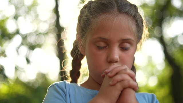 child pray. young gratitude a god religion concept. little girl in nature outdoors praying dreams of happiness to god. praise worship freedom concept. lifestyle kid praying in the forest