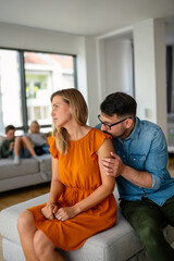 Sad pensive couple thinking of relationships problems sitting on sofa, conflicts in marriage.