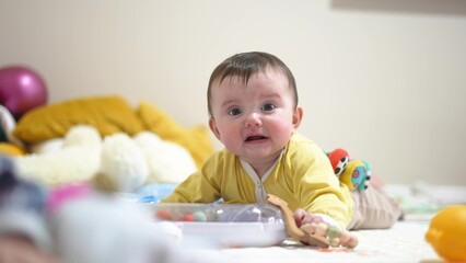 baby 6 months playing with a toy. kid in kindergarten playing on the floor many toys indoors. happy family baby dream concept. little infant baby play lifestyle in kindergarten. happy childhood