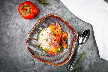 side view of a dish of baked persimmons, colored peppers, rice and seeds