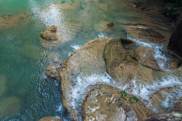 Erawan National Park in Thailand. Erawan Waterfall is a popular tourist destination and famous for its emerald blue water. Deep forest in tropical climate with fantasy atmosphere.