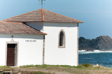 A small chapel formed by a construction and a bell tower on the edge of the sea