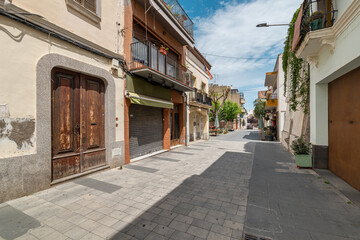 Narrow paved street with old buildings in Vilassar de Mar