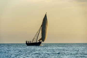 dhow traditional sailing vesssels of zanzibar tanzania at dusk viewed on a calm dusk evening

