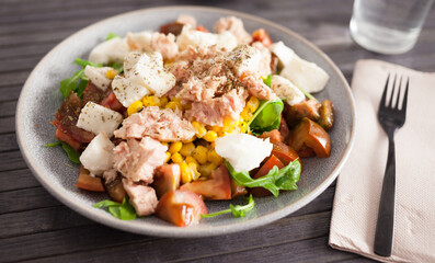 Plate of salad with tuna, corn, tomatoes and arugula