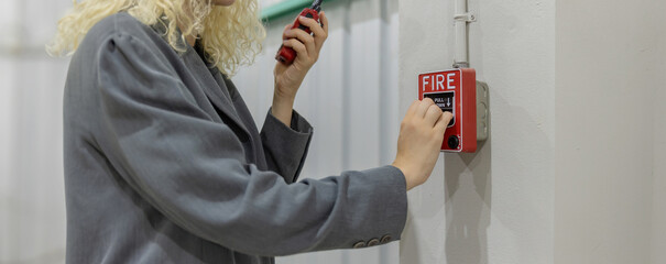 Foreman or worker pushing fire alarm on the wall. A fire! or Emergency case at the factory...