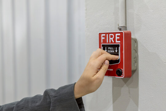 Foreman or worker pushing fire alarm on the wall. A fire! or Emergency case at the factory building. Emergency of Fire alarm or alert or bell warning equipment