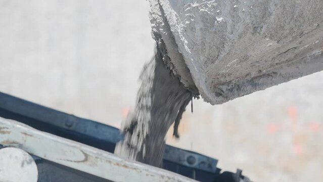 Concrete pours from the pipe of concrete mixer - close up. Long static clip.