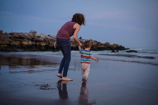 A young Caucasian mom with her toddler son on the beach