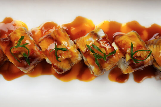 Sushi rolls with eel and teriyaki sauce, close-up.