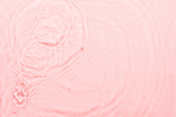 Fototapeta na wymiar Water pink surface abstract background. Waves and ripples texture of cosmetic aqua moisturizer with bubbles.