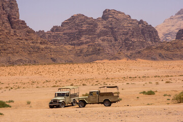 Jordan, Wadi Rum desert. Two SUVs set against backdrop of incredible scenery. Martian city...