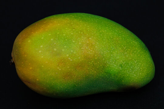 Single whole mango harumanis isolated on black
