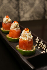 Sushi rolls with salmon, lime, red caviar, close-up