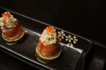 Sushi rolls with salmon, lime, red caviar, close-up