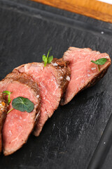 Beef tenderloin. Close up photo with a dish made of beef tenderloin medium rare steak. Barbecue steakhouse grill menu photo.