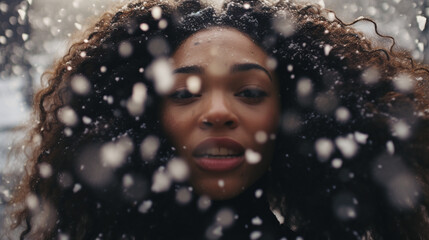 Close-up of a serene Black woman amid falling snowflakes, exuding warmth in cold