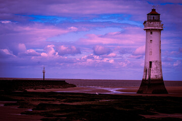 An historic Lighthouse on the beach with the sea in the background.
