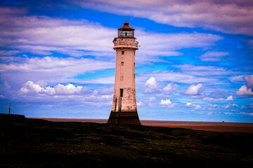 An historic Lighthouse on the beach with the sea in the background.