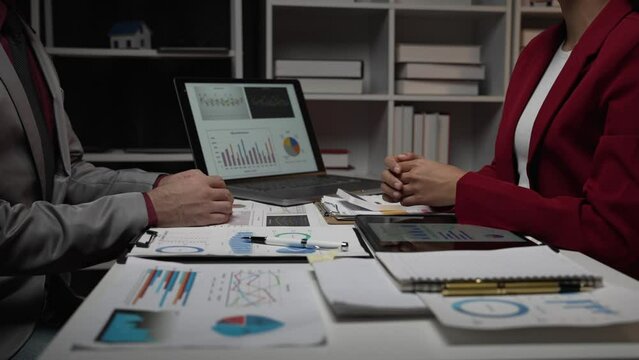 Two investors analyze and write financial data and business reports together, plan strategies and brainstorm at the office together. Finance and Economy business idea