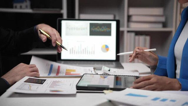 Two investors analyze and write financial data and business reports together, plan strategies and brainstorm at the office together. Finance and Economy business idea
