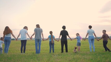 large group of people holding hands. family big community outdoors in the park holding hands together. happy family kid dream concept. people support each other joined hands nature back lifestyle view