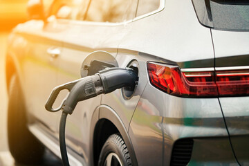 Electric car charging in the city, sunny background. Charging port of an electric car. Charging...