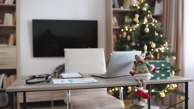 Modern laptop computer on wood table. Cozy comfortable home living room with Christmas decor. Home office desk workspace. Mockup copy space. Winter sales, online shopping