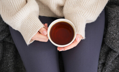 Top view of young woman's hands drinking green tea.Casual day at home in loungewear