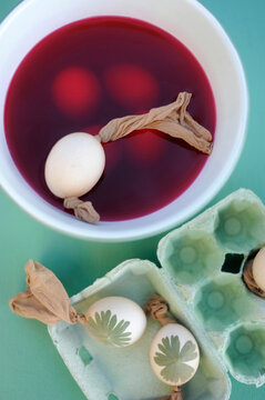 Easter eggs dyeingin bowl with red dye